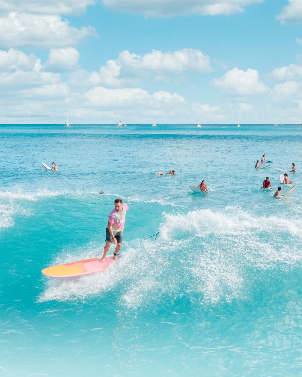 Surfers enjoying a bright summer day on the blue ocean waves.