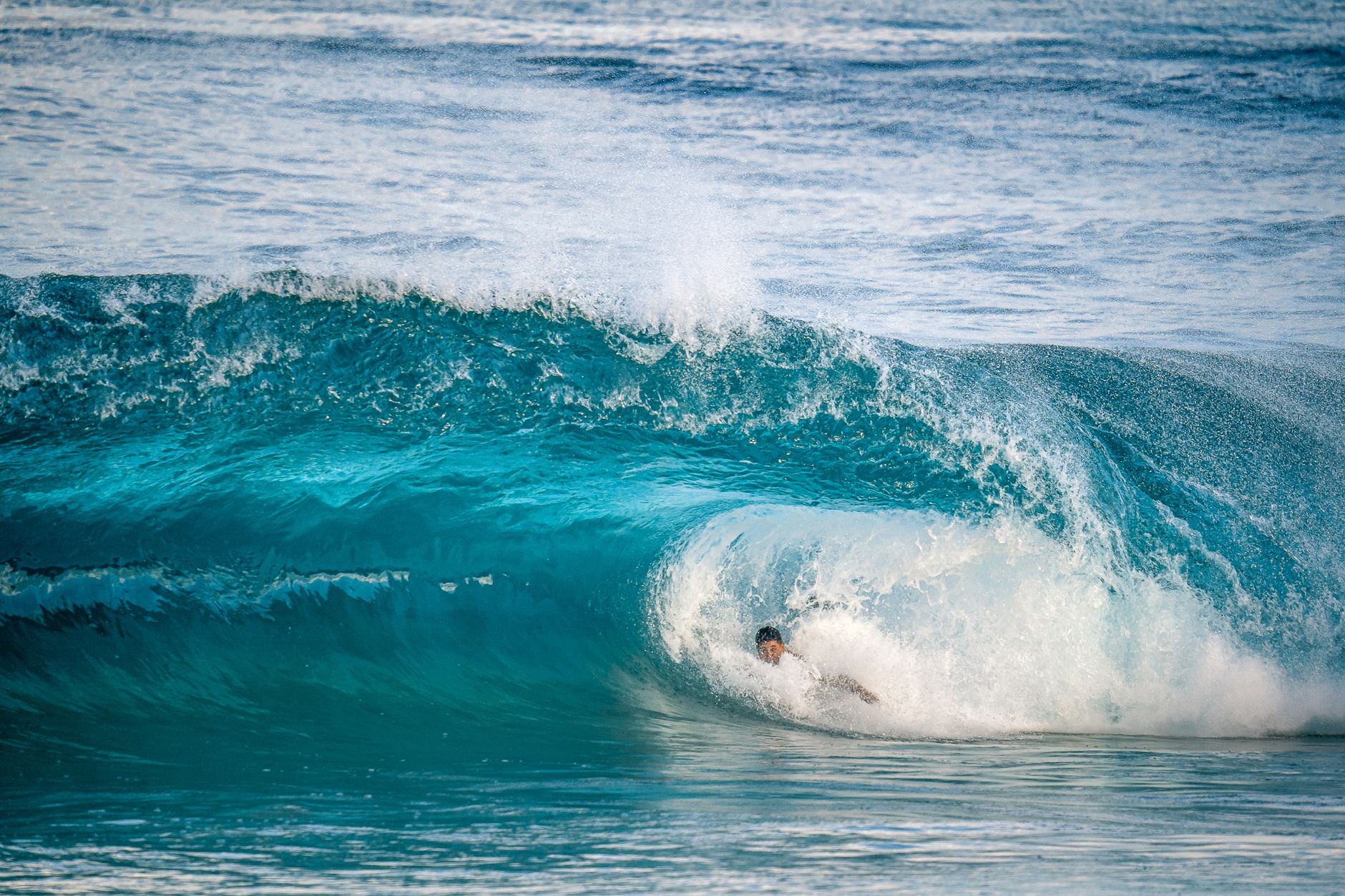 Surfer skillfully navigates through a powerful ocean wave in an exhilarating display of skill.